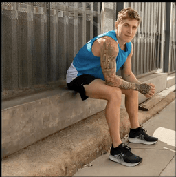 a guy in blue sleeveless sitting